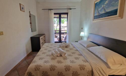 a bedroom with a bed with two towels on it at Porto Pollo, Il borgo villetta 3 camere da letto in Porto Pollo