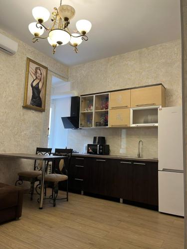 a kitchen with a table and a white refrigerator at Monro-style in the historical center in Odesa