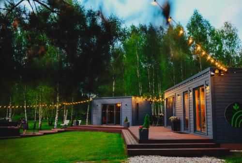 a small house with christmas lights in a yard at Baldones dabas retrīts - Exclusive private nature retreat with optional jacuzzi and sauna near Riga in Pulkarne