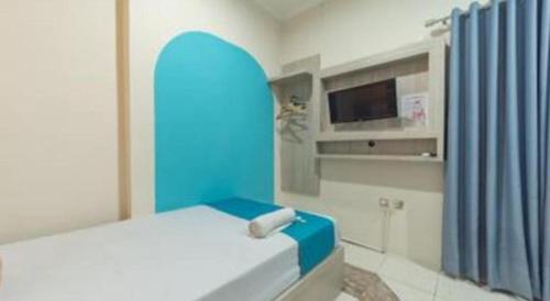 a bedroom with a bed with a blue head board at OYO Life 92127 Skyland Pasteur in Bandung