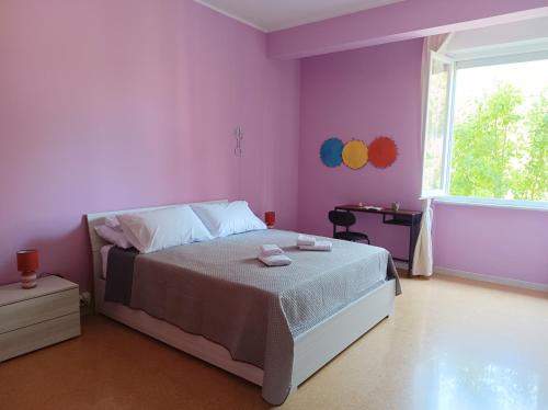 a bedroom with a bed with purple walls and a window at Casa Pablo - Ospedale Maggiore in Parma