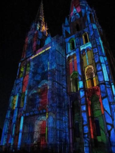 a tall building with colorful lights on it at night at Charmant studio à deux pas de la cathédrale in Chartres