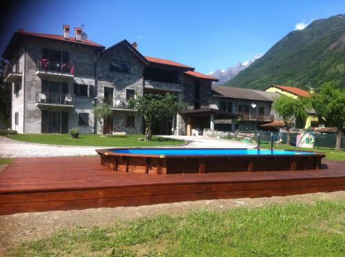 a house with a swimming pool in front of a building at Casa Vacanze Zia Vivina in Sorico