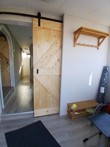 a room with a sliding barn door and a bench at Ruim en rustig chalet in Nationaal park de Drentsche Aa max 5 prs in Anloo