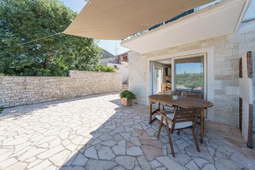 a patio with a wooden table and chairs and an umbrella at Casa Di Sebastian in Gaios