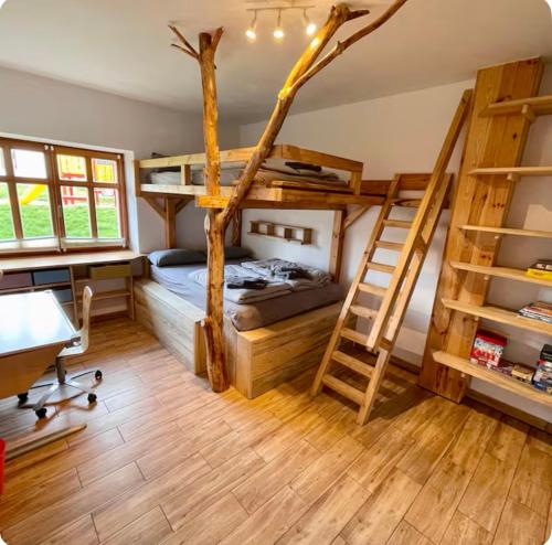 una camera con letti a castello, scrivania e scala di Grosszügige Wohnung im Hause des Jungbauern a Penkun