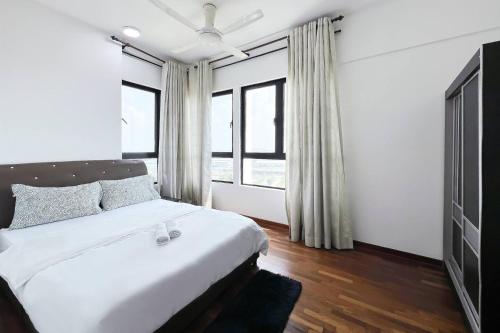 une chambre avec un grand lit blanc et des fenêtres dans l'établissement 7 Pax 2 Bedroom iCity Shah Alam, à Shah Alam