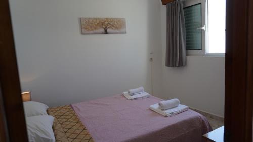 a bedroom with a bed with two towels on it at Sugarcubes by Evagstays in Faliraki