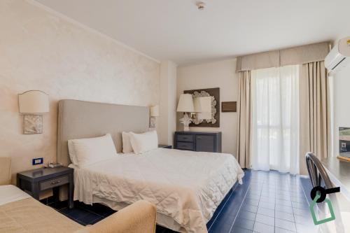 a hotel room with a bed and a window at HOTIDAY Room Collection - Mattinata Faraglioni in Mattinata