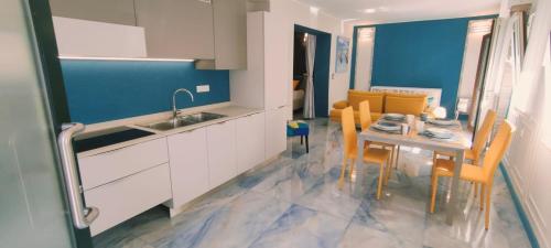 a kitchen and dining room with a table and chairs at Blu House in Chioggia