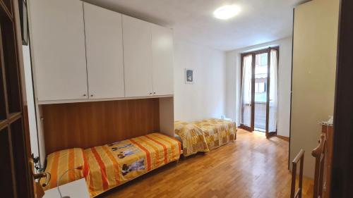 two beds in a room with white cabinets at Campione - Garda Wind Apartment 2 bedrooms in Campione del Garda