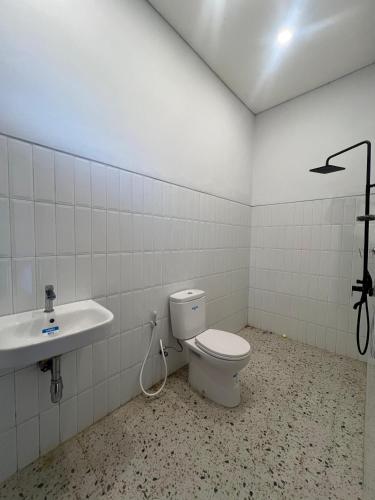 a bathroom with a toilet and a sink at Villa Mecca in Batu
