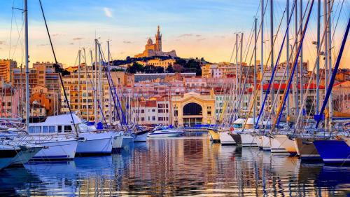 un groupe de bateaux amarrés dans un port avec une ville dans l'établissement Le cabanon du Vieux Port, à Marseille