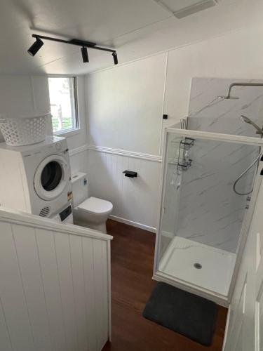 ein Badezimmer mit Dusche und Waschmaschine in der Unterkunft Martali Cottage in Wyberba