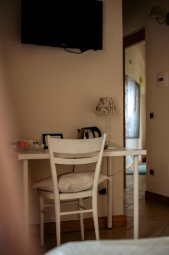 a white table with a chair and a desk with a television at Masseria Fontana dei Fieri in Pietrelcina