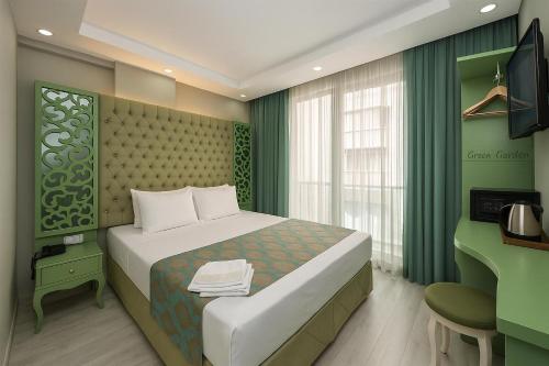 a bedroom with a bed and a desk with a computer at Green Garden Hotel - Bahçelievler in Istanbul