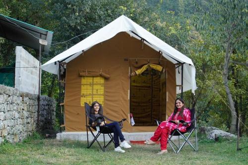 two women sitting in chairs in front of a tent at Uphill Adventures and Meditation I Dharamshala in Dharamshala