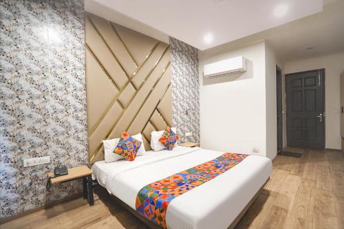 a bedroom with a large bed and a wall at FabHotel Novis Stayz in Noida
