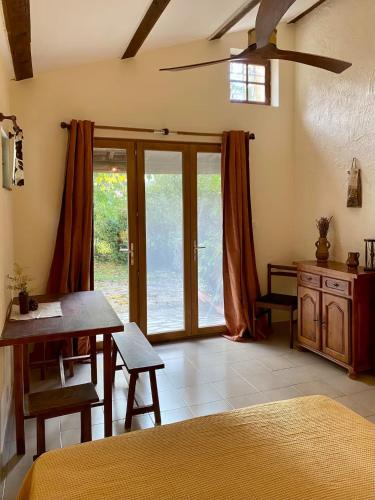 a bedroom with a bed and a table and a window at Mas Pinède et Pierre in Saint-Julien-de-Peyrolas
