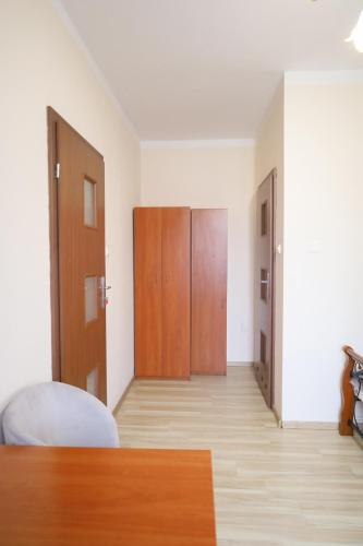 a room with a bed and wooden doors in it at Gospodarstwo Agroturystyczne Pod Lasem Maria Płazio in Narol
