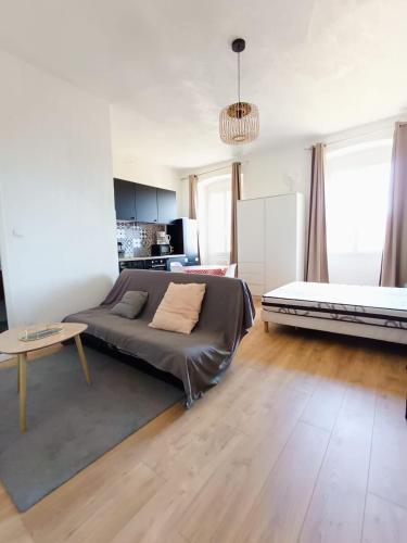 un salon avec un lit et une table dans l'établissement Magnifique Grand 30m2 refait à neuf en 2025 lumineux 4 couchages hyper centre Corte 13 cours paoli wifi tv lave linge, à Corte