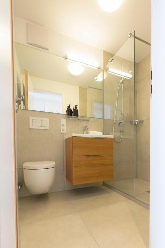 a bathroom with a toilet and a sink and a shower at Huber Living in Germering