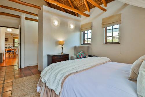 a bedroom with a white bed and a living room at Plum Tree Cottage in McGregor
