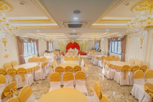 a banquet hall with white and yellow tables and chairs at NEW PALACE HOTEL in Quang Ngai