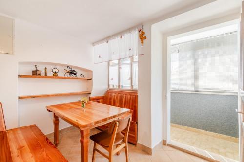 a dining room with a wooden table and a window at Holiday Homes Pr Pelaku with Sauna in Slappe dʼIdria