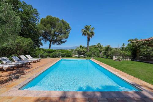 - une piscine dans un jardin avec des chaises et des arbres dans l'établissement REF 1849 - Cannes - Villa Provencal Style to rent, au Cannet