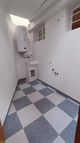 a bathroom with a checkered floor and a toilet at La BODEGA DE ROSARIO in Algodonales