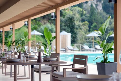 a restaurant with tables and chairs next to a pool at Alkyna Lifestyle Beach Resort - Adults Only in Agios Gordios