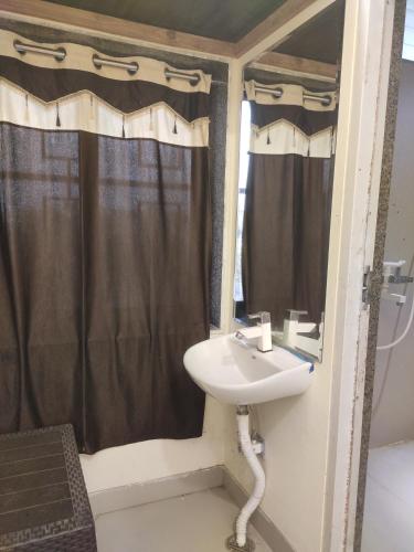 a bathroom with a sink and a shower at Krishna Bhavan And Events in Nāgaur