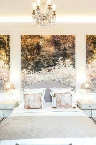 - une chambre avec un lit blanc et un lustre dans l'établissement Chateau De Londigny & Spa Retreat, à Londigny