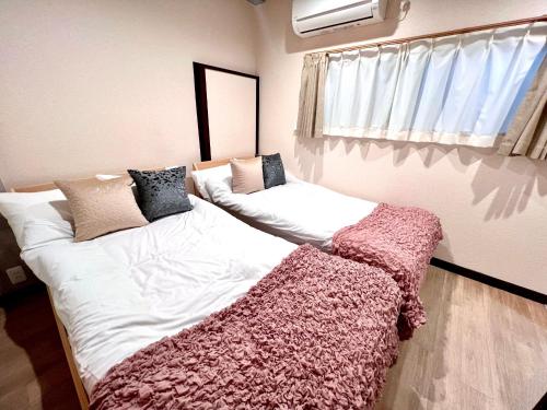 En eller flere senge i et værelse på KAMATA EAST and SWEET