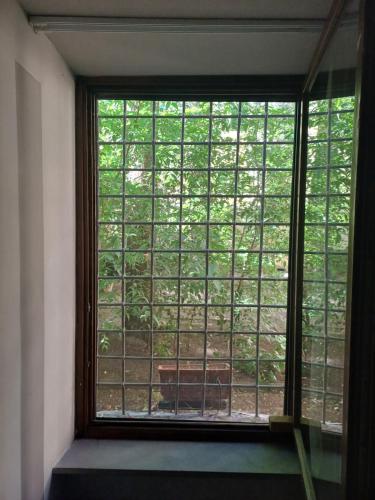 a window in a room with a view of trees at La Colonna (Historic Centre) in Lucca