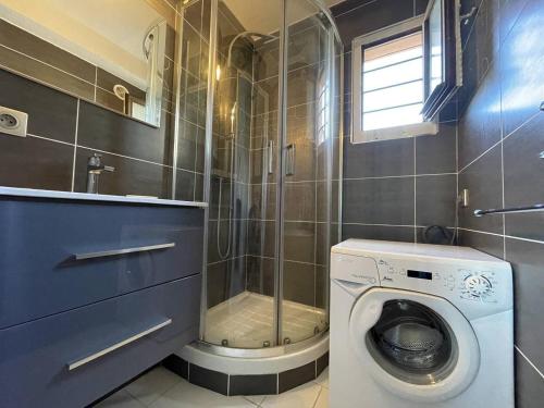 La salle de bains est pourvue d'un lave-linge et d'une douche. dans l'établissement APPARTEMENT AVEC CHAMBRE ET CABINE SEPAREE À DEUX PAS DES PLAGES, au Cap d'Agde