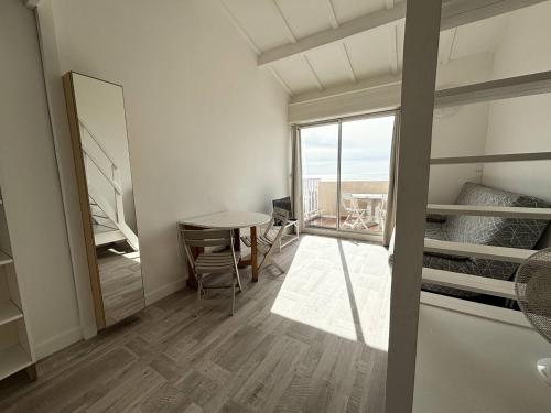 une chambre avec un lit, une table et une fenêtre dans l'établissement APPARTEMENT AVEC TRES BELLE VUE MER, au Cap d'Agde