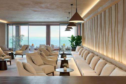 a waiting room with chairs and tables and the ocean at Alkyna Lifestyle Beach Resort - Adults Only in Agios Gordios