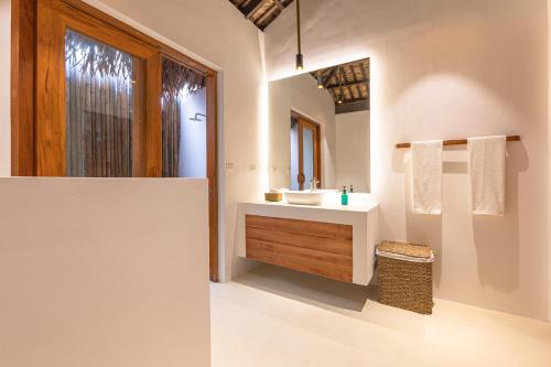 a white bathroom with a sink and a mirror at SEACLUB Siargao in General Luna