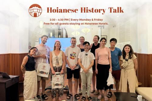 a group of people standing in front of a sign at Hoianese Sunset Serenity Hotel in Hoi An