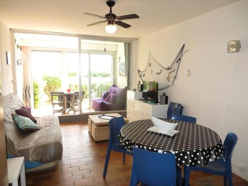 un salon avec une table et des chaises bleues dans l'établissement APPARTEMENT AVEC DEUX CHAMBRES FACE A LA MER, au Cap d'Agde