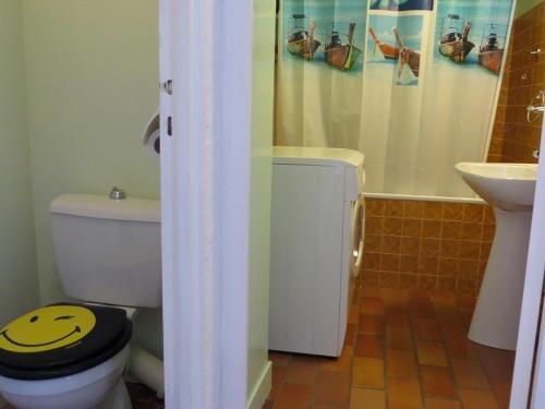 une salle de bain avec des toilettes avec un smiley sur le couvercle dans l'établissement APPARTEMENT AVEC DEUX CHAMBRES FACE A LA MER, au Cap d'Agde
