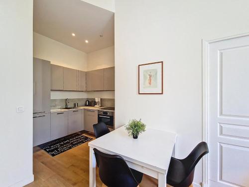 une cuisine avec une table blanche et des chaises noires dans l'établissement Nestor&Jeeves - JEAN MEDECIN - Central - Modern, à Nice