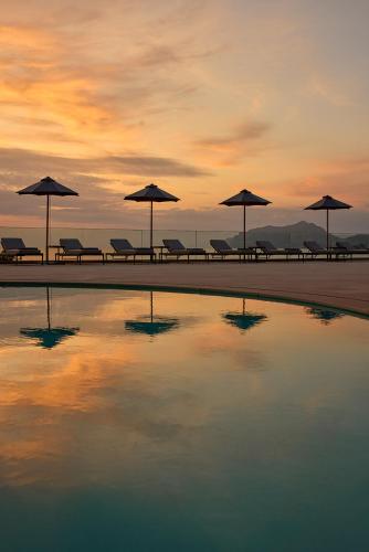 a group of tables with umbrellas on a beach at Alkyna Lifestyle Beach Resort - Adults Only in Agios Gordios