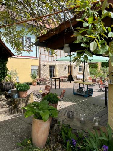 a patio with a table and chairs and an umbrella at Hiestands Gästehaus - Weingut & Hofbrennerei in Guntersblum
