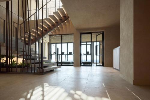 an empty lobby with glass doors and a staircase at Alkyna Lifestyle Beach Resort - Adults Only in Agios Gordios