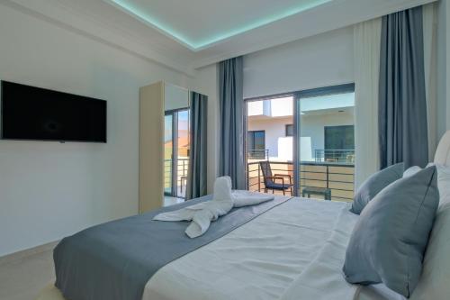 a bedroom with a bed with a television and a balcony at ADER DOĞA Villaları 6 in Zikirciler