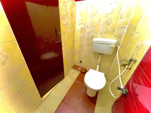 a bathroom with a toilet and a shower stall at COZY NEST Homestay & Rooftop Cafe in Agra