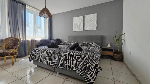 a bedroom with a bed with black and white sheets at Central Charm - Bedroom & Kitchen Apartment near the Main Station Hauptbahnhof in Wuppertal